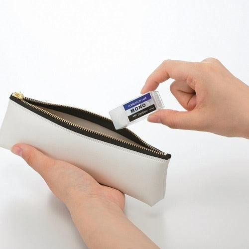 Tombow Mono correction tape shown being inserted into white pouch dispenser with gold zipper
