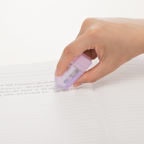 Tombow Mono-Pocket correction tape in-use demonstration on notebook page, purple 5mm width tape dispenser held in hand