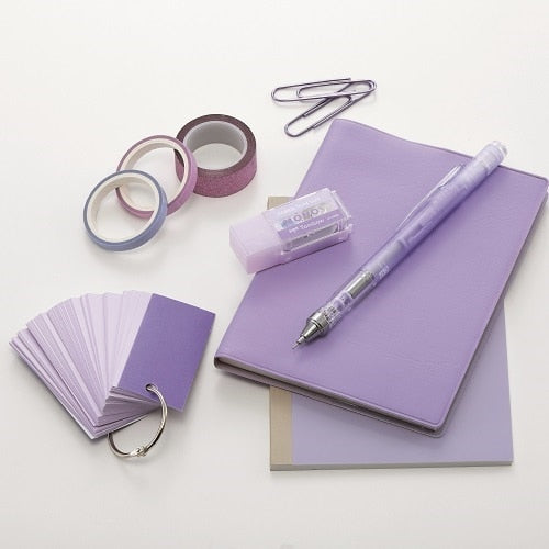 Purple stationery collection featuring Mono-Pocket correction tape with notebooks, pen, and tape dispenser