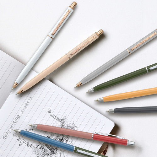 Interact Ballpoint Pen collection displayed with notebook showing writing samples and color variety comparison